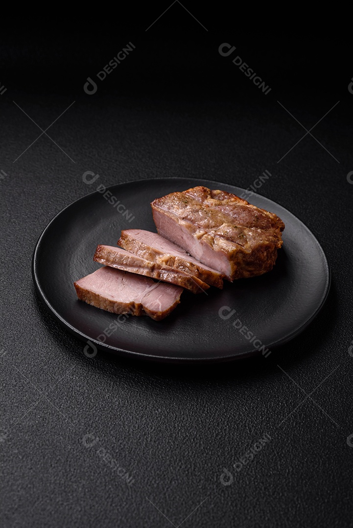 Delicioso suculento bife de porco ou de vaca cozido na grelha com sal e especiarias sobre um fundo de concreto texturizado