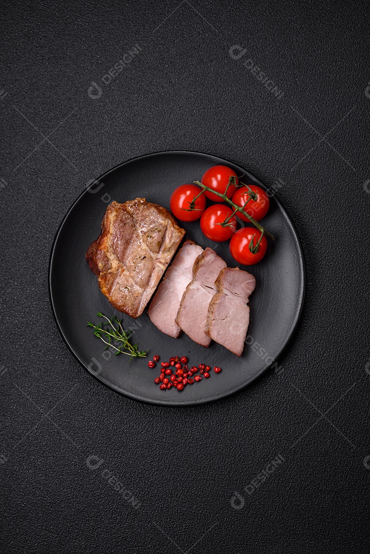 Delicioso suculento bife de porco ou de vaca cozido na grelha com sal e especiarias sobre um fundo de concreto texturizado