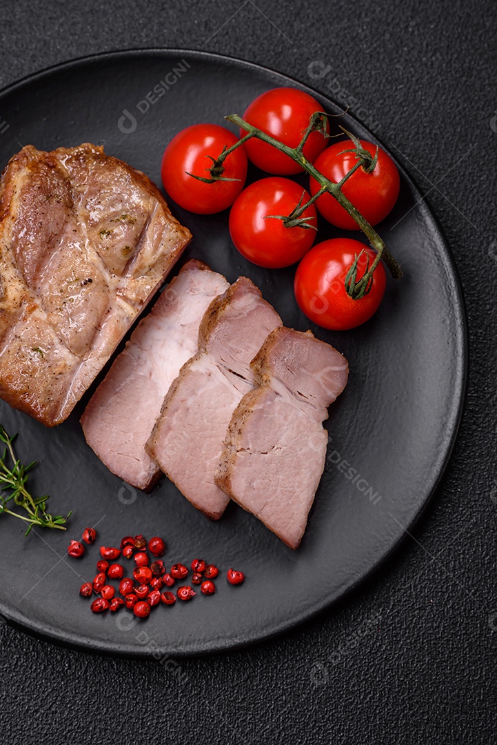 Delicioso suculento bife de porco ou de vaca cozido na grelha com sal e especiarias sobre um fundo de concreto texturizado