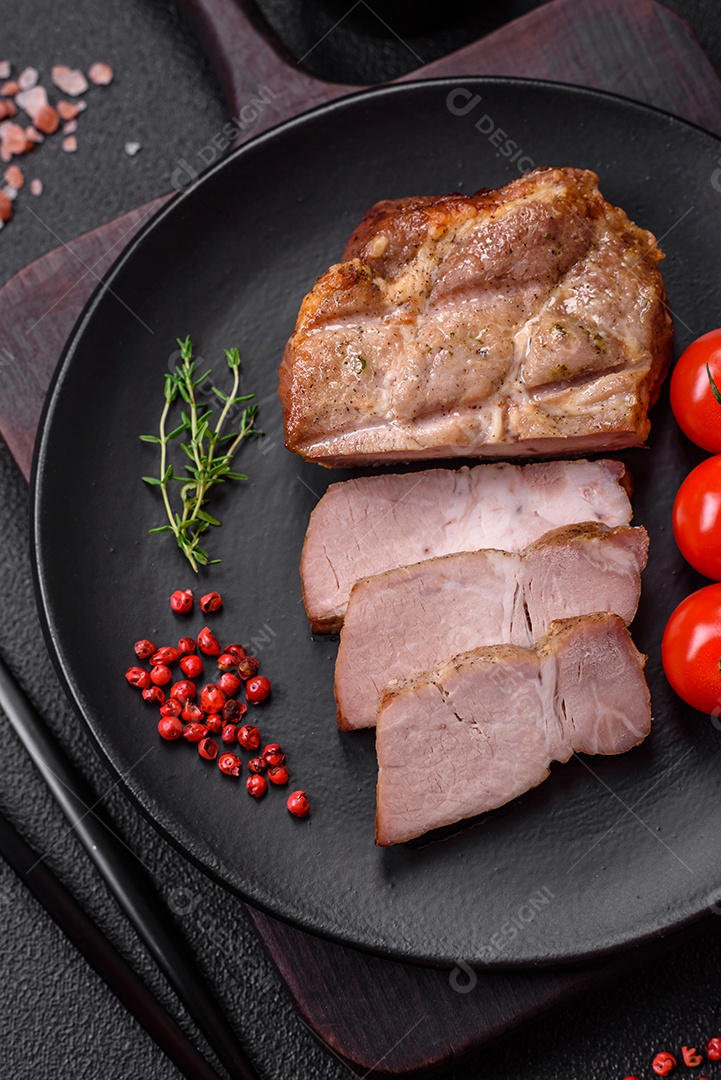 Delicioso suculento bife de porco ou de vaca cozido na grelha com sal e especiarias sobre um fundo de concreto texturizado