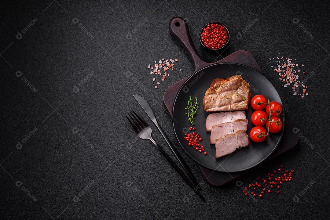 Delicioso suculento bife de porco ou de vaca cozido na grelha com sal e especiarias sobre um fundo de concreto texturizado