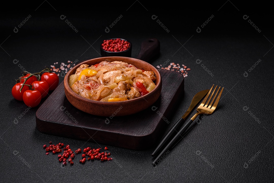 Um delicioso prato composto por fatias de frango, pimentão e cebola com sal e especiarias sobre um fundo escuro de concreto