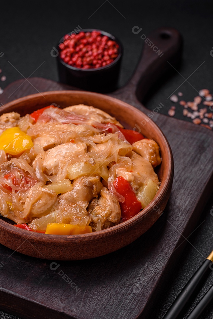 Um delicioso prato composto por fatias de frango, pimentão e cebola com sal e especiarias sobre um fundo escuro de concreto