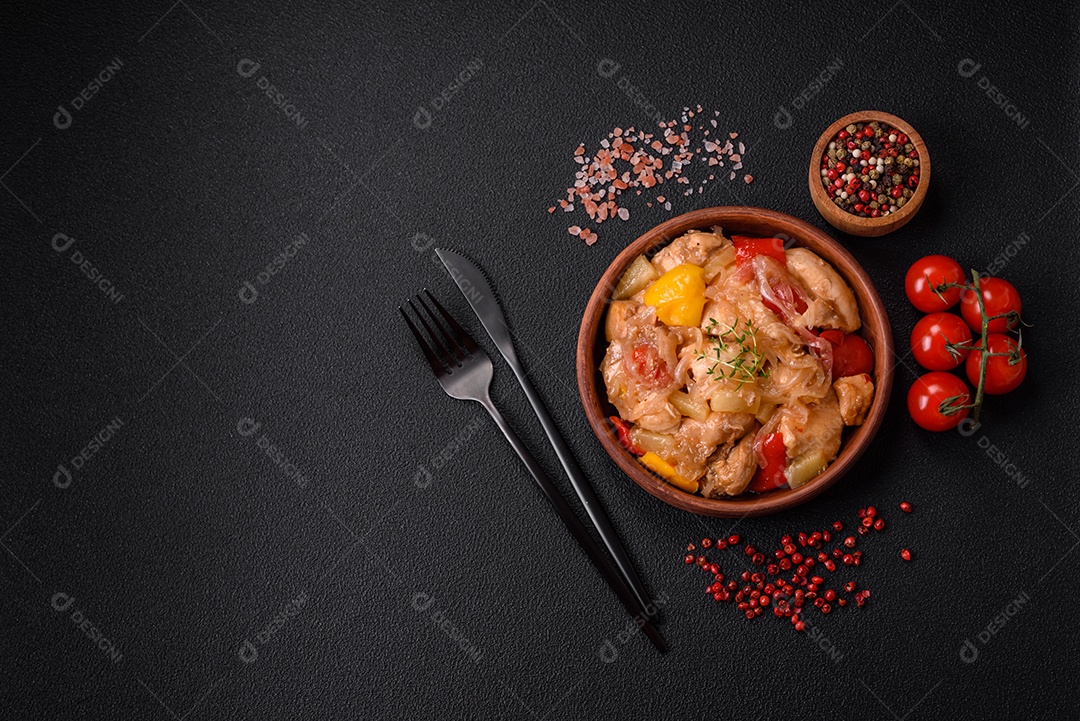 Um delicioso prato composto por fatias de frango, pimentão e cebola com sal e especiarias sobre um fundo escuro de concreto