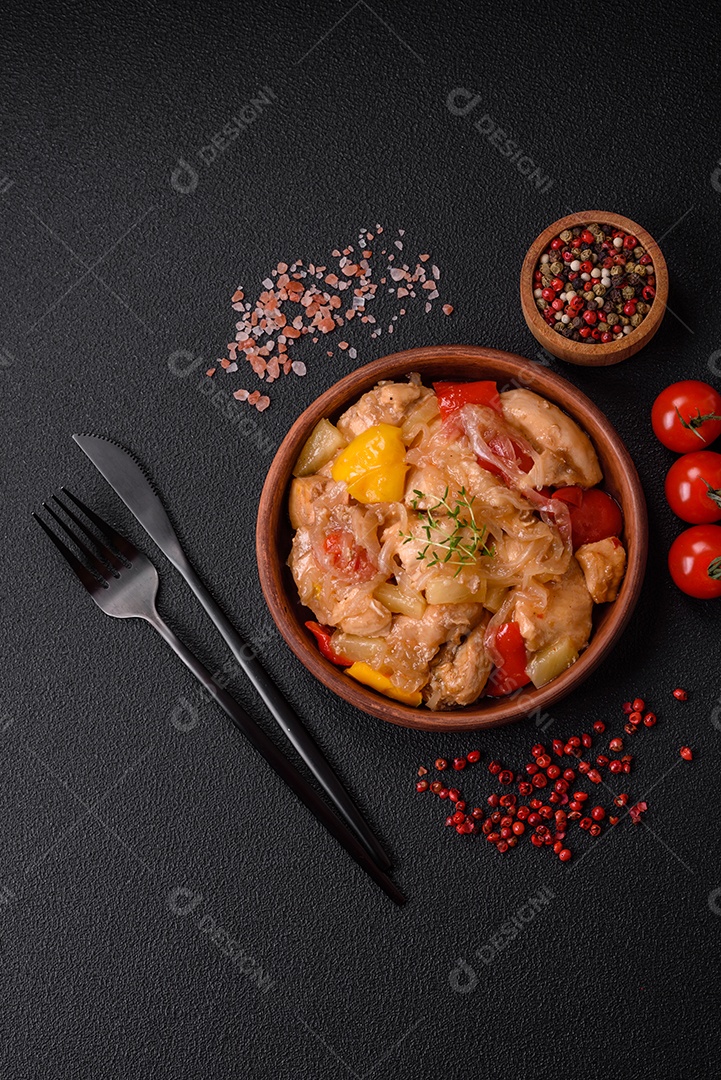 Um delicioso prato composto por fatias de frango, pimentão e cebola com sal e especiarias sobre um fundo escuro de concreto
