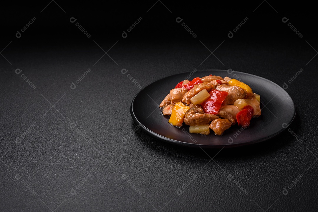 Um delicioso prato composto por fatias de frango, pimentão e cebola com sal e especiarias sobre um fundo escuro de concreto