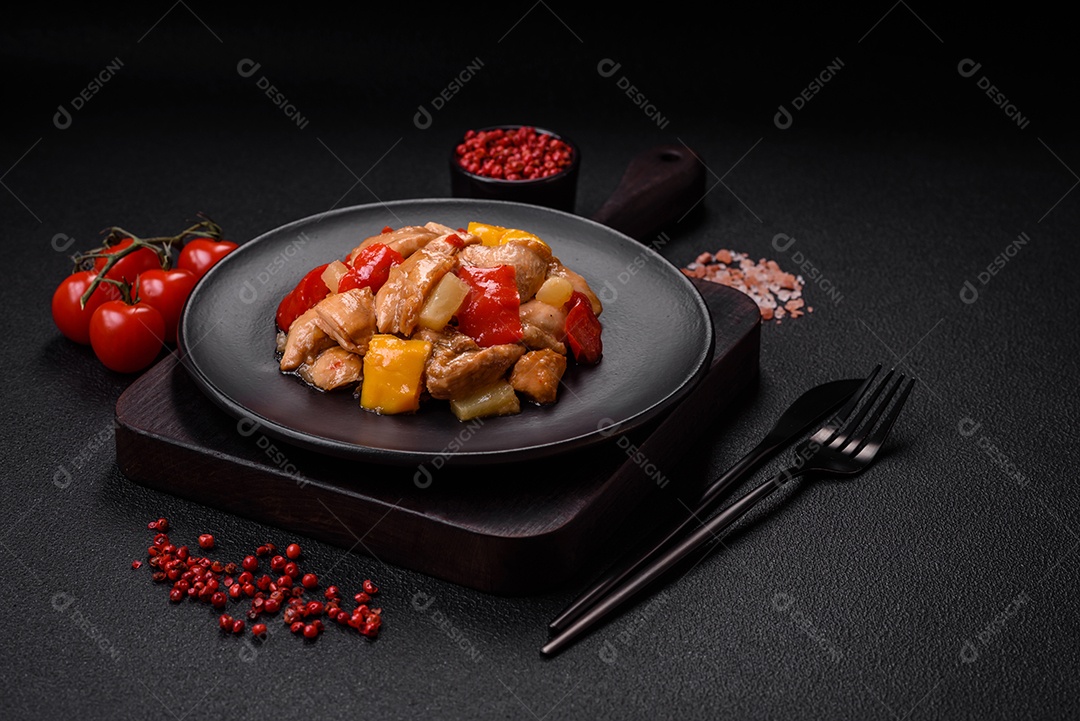 Um delicioso prato composto por fatias de frango, pimentão e cebola com sal e especiarias sobre um fundo escuro de concreto