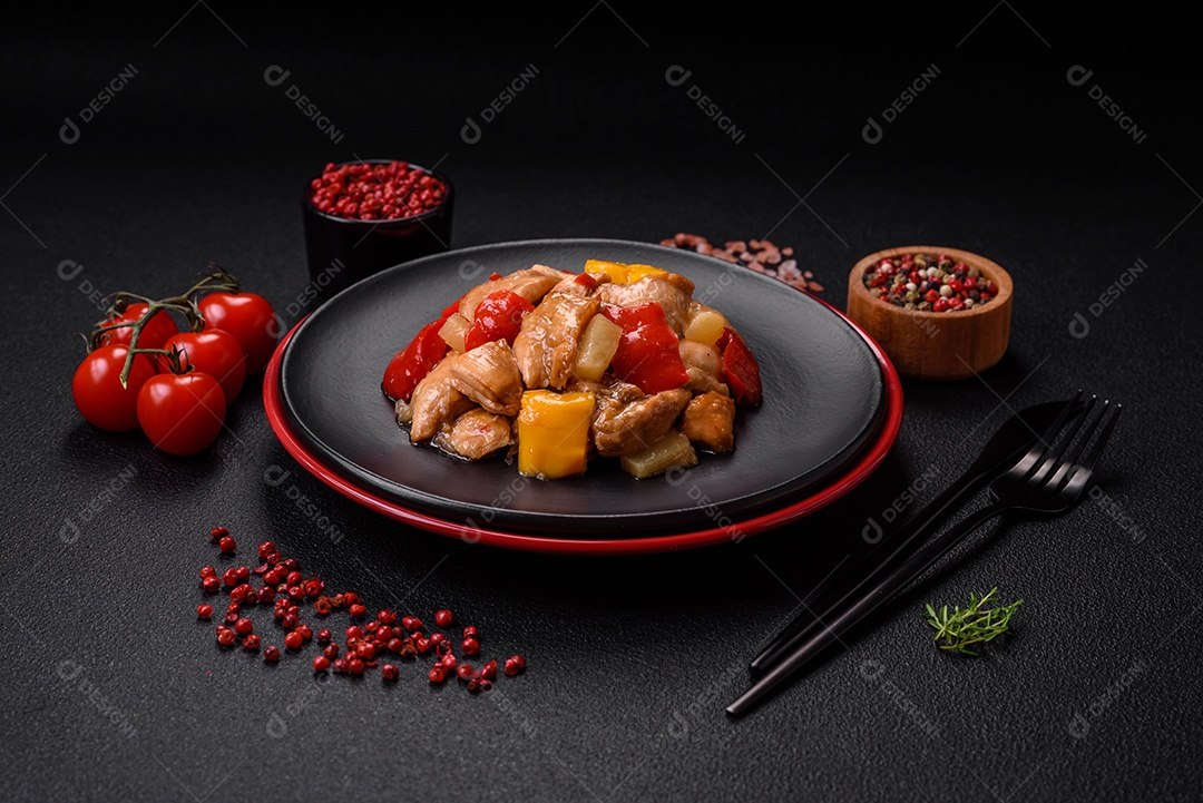 Um delicioso prato composto por fatias de frango, pimentão e cebola com sal e especiarias sobre um fundo escuro de concreto