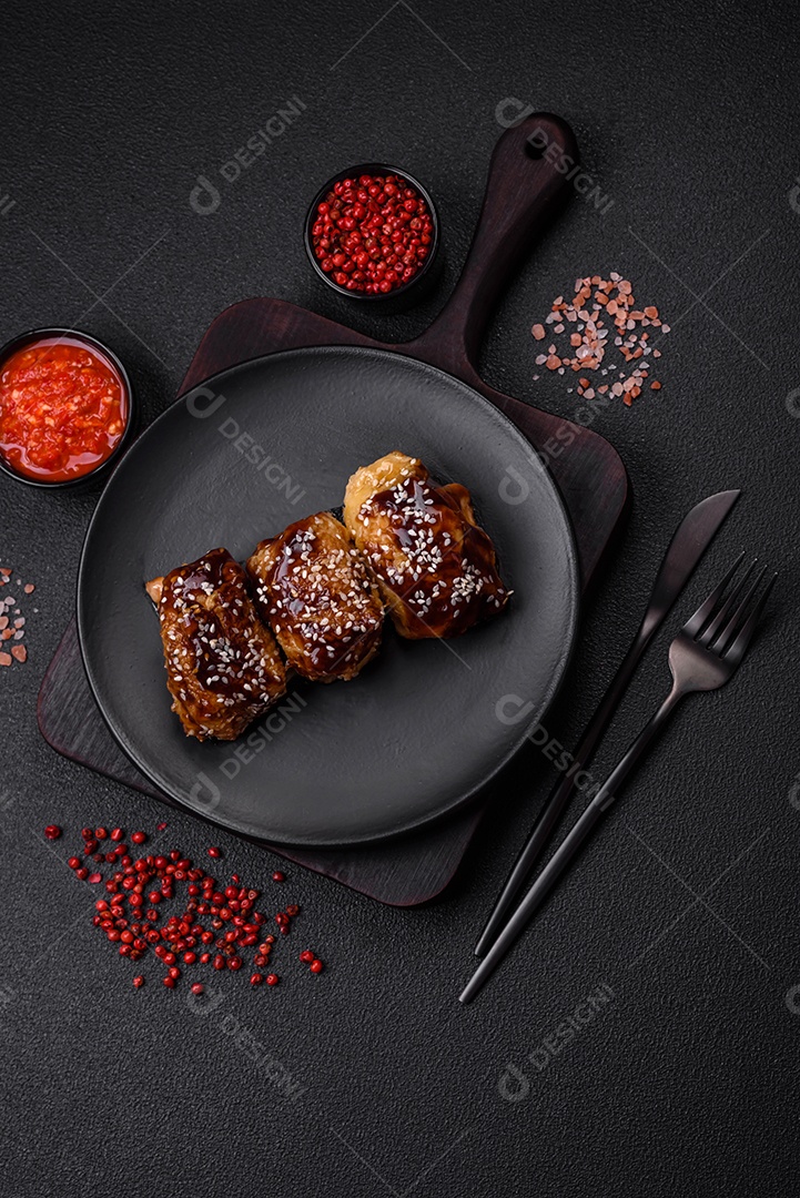 Delicioso frango frito suculento com molho teriyaki agridoce e sementes de gergelim em um fundo escuro de concreto