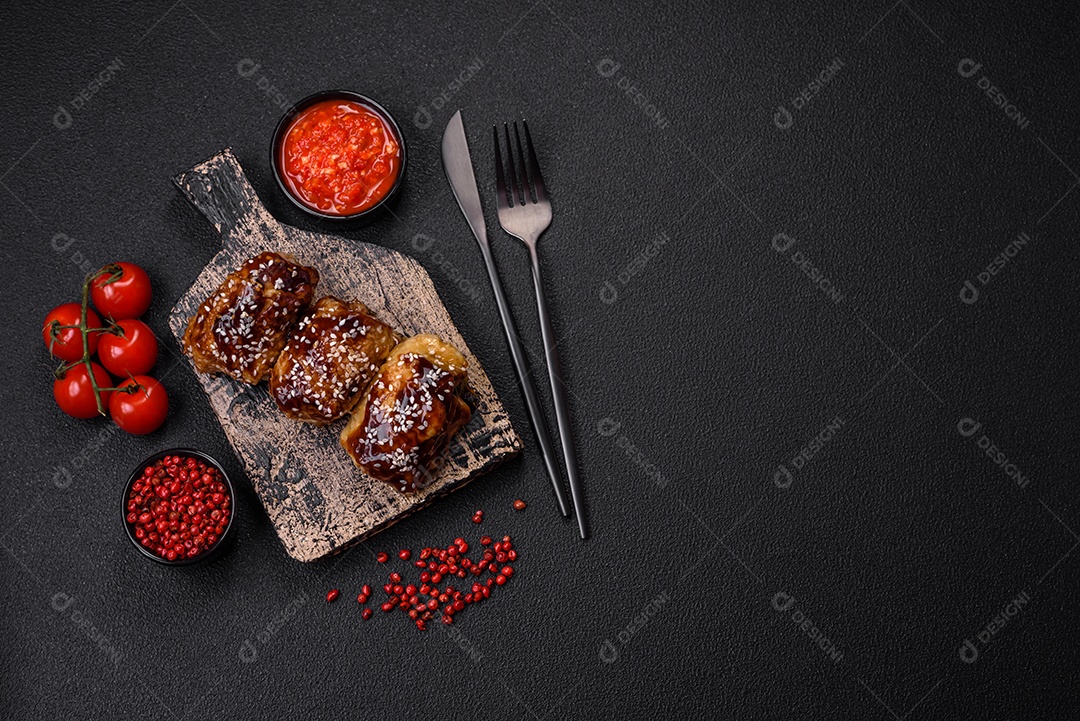 Delicioso frango frito suculento com molho teriyaki agridoce e sementes de gergelim em um fundo escuro de concreto