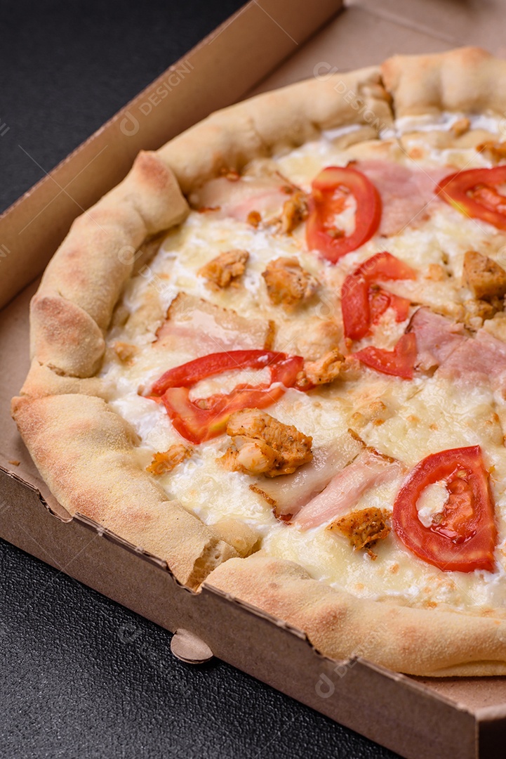 Deliciosa pizza quente com frango, tomate, queijo e bacon, com sal e especiarias e sobre fundo escuro de concreto