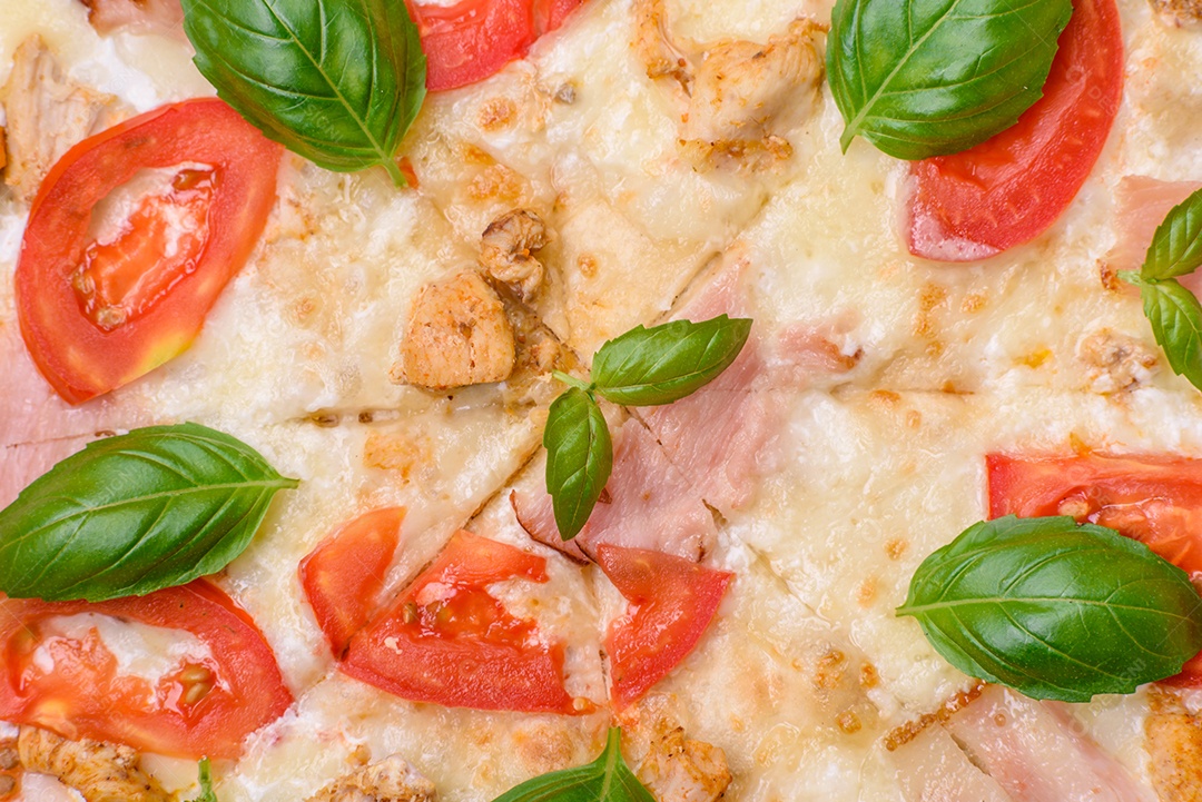 Deliciosa pizza quente com frango, tomate, queijo e bacon, com sal e especiarias e sobre fundo escuro de concreto