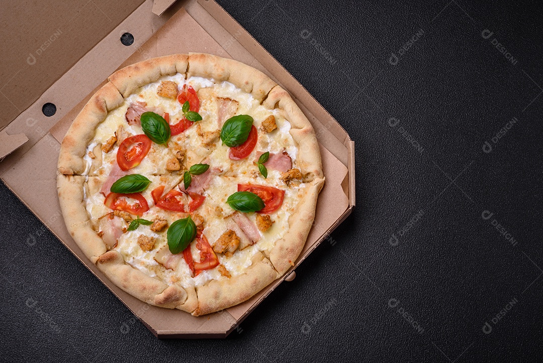Deliciosa pizza quente com frango, tomate, queijo e bacon, com sal e especiarias e sobre fundo escuro de concreto