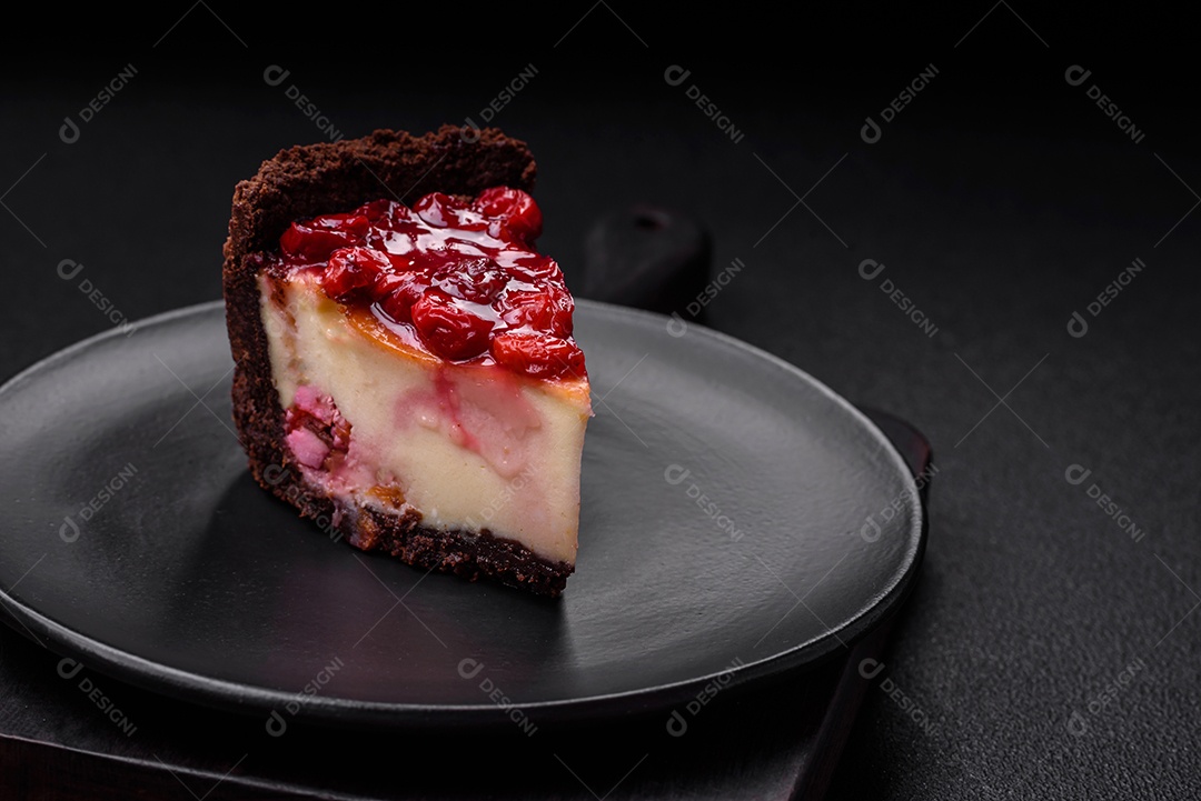 Delicioso bolo de cheesecake doce com queijo mascarpone, bagas de cereja e geléia sobre um fundo escuro de concreto