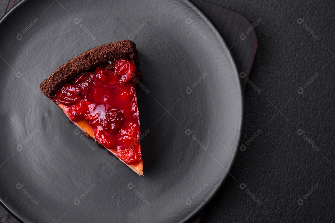 Delicioso bolo de cheesecake doce com queijo mascarpone, bagas de cereja e geléia sobre um fundo escuro de concreto