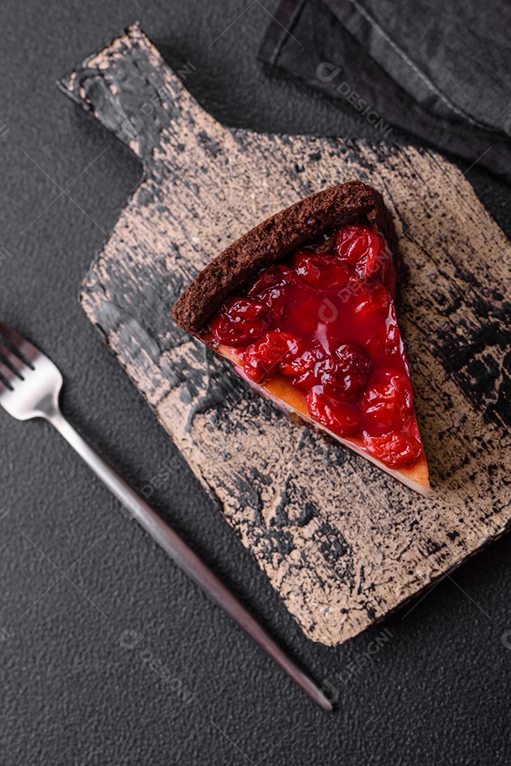 Delicioso bolo de cheesecake doce com queijo mascarpone, bagas de cereja e geléia sobre um fundo escuro de concreto