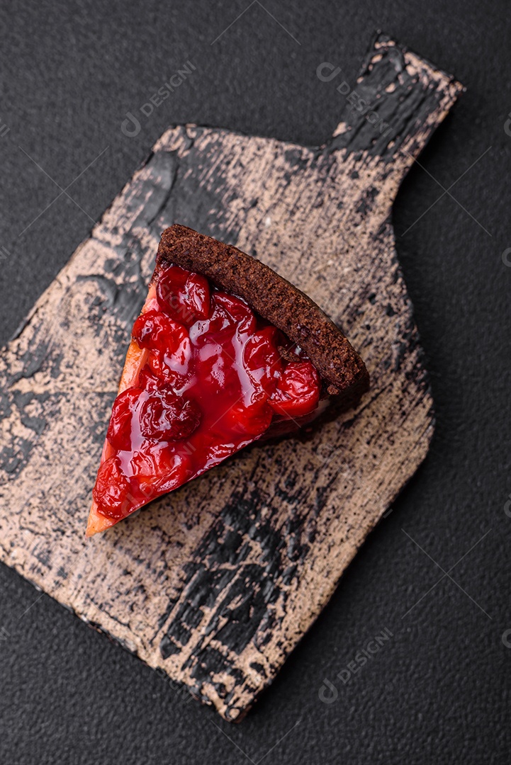 Delicioso bolo de cheesecake doce com queijo mascarpone, bagas de cereja e geléia sobre um fundo escuro de concreto