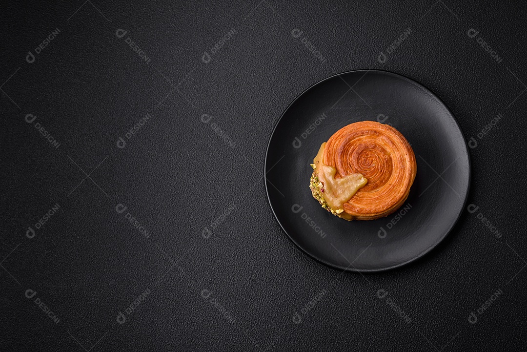 Croissant redondo de massa folhada com recheio de framboesa ou rolo de Nova Iorque sobre fundo escuro de concreto