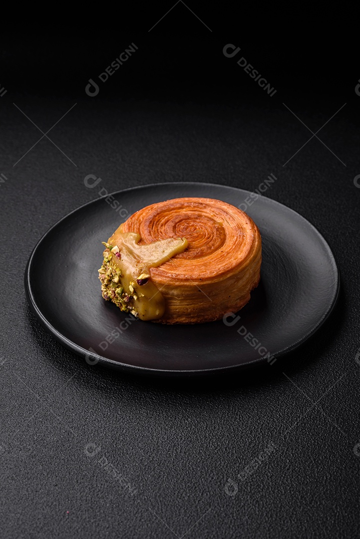 Croissant redondo de massa folhada com recheio de framboesa ou rolo de Nova Iorque sobre fundo escuro de concreto