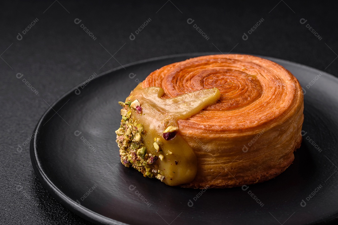 Croissant redondo de massa folhada com recheio de framboesa ou rolo de Nova Iorque sobre fundo escuro de concreto