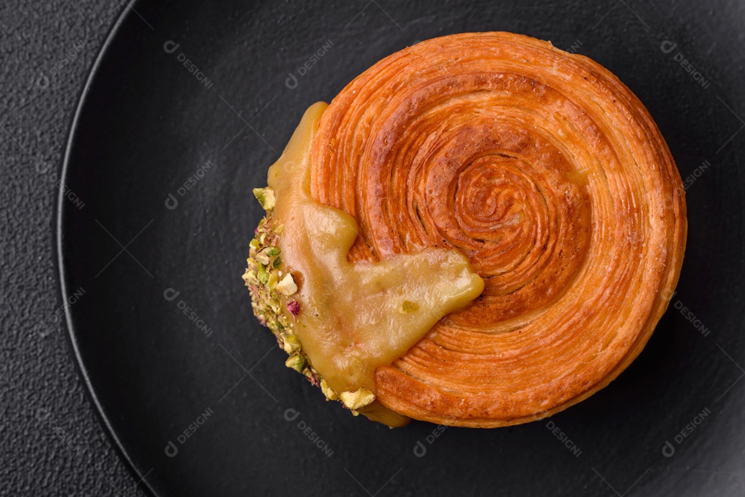 Croissant redondo de massa folhada com recheio de framboesa ou rolo de Nova Iorque sobre fundo escuro de concreto