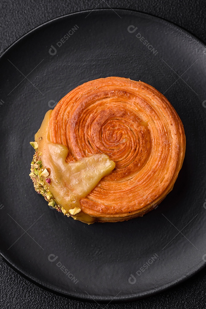 Croissant redondo de massa folhada com recheio de framboesa ou rolo de Nova Iorque sobre fundo escuro de concreto