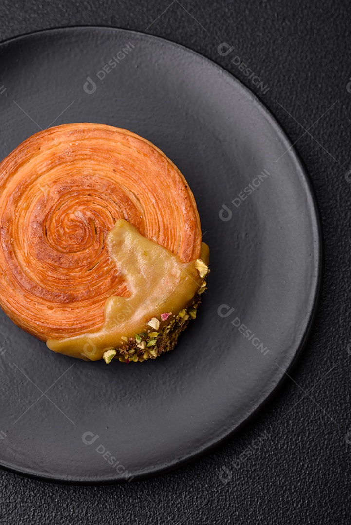 Croissant redondo de massa folhada com recheio de framboesa ou rolo de Nova Iorque sobre fundo escuro de concreto