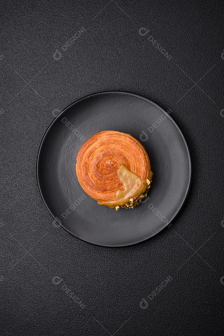 Croissant redondo de massa folhada com recheio de framboesa ou rolo de Nova Iorque sobre fundo escuro de concreto