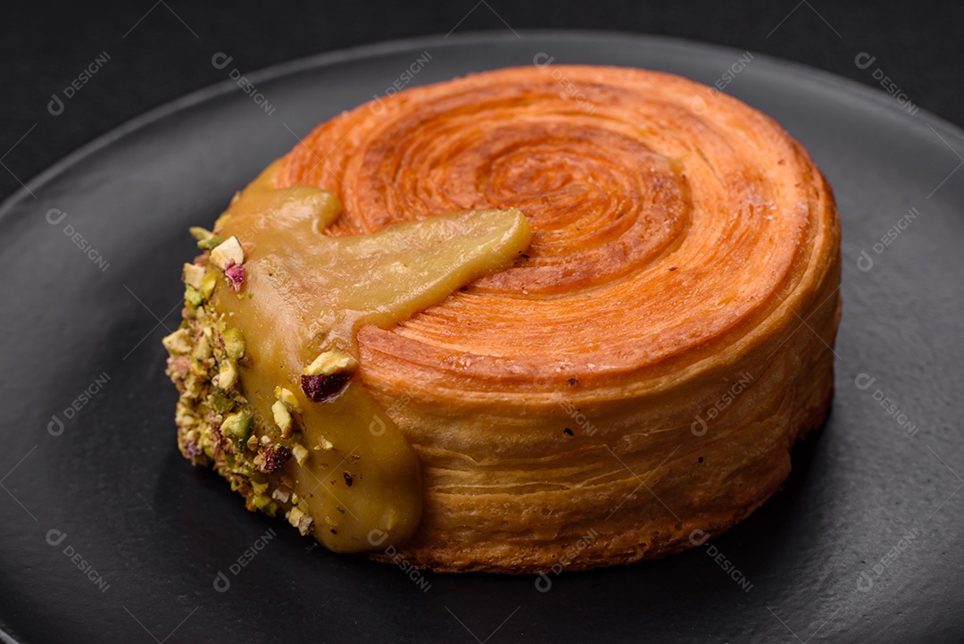 Croissant redondo de massa folhada com recheio de framboesa ou rolo de Nova Iorque sobre fundo escuro de concreto