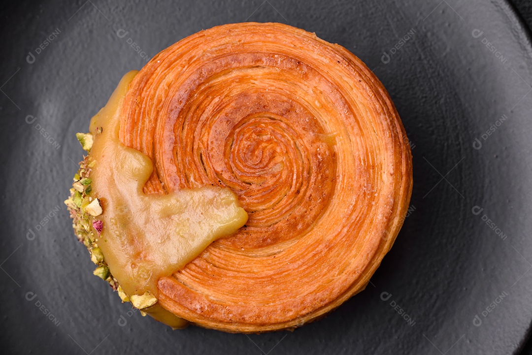 Croissant redondo de massa folhada com recheio de framboesa ou rolo de Nova Iorque sobre fundo escuro de concreto