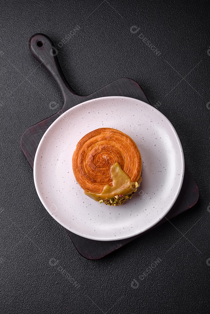 Croissant redondo de massa folhada com recheio de framboesa ou rolo de Nova Iorque sobre fundo escuro de concreto