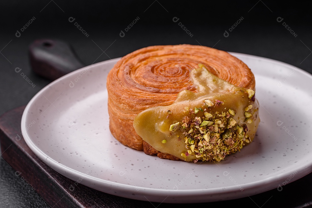 Croissant redondo de massa folhada com recheio de framboesa ou rolo de Nova Iorque sobre fundo escuro de concreto