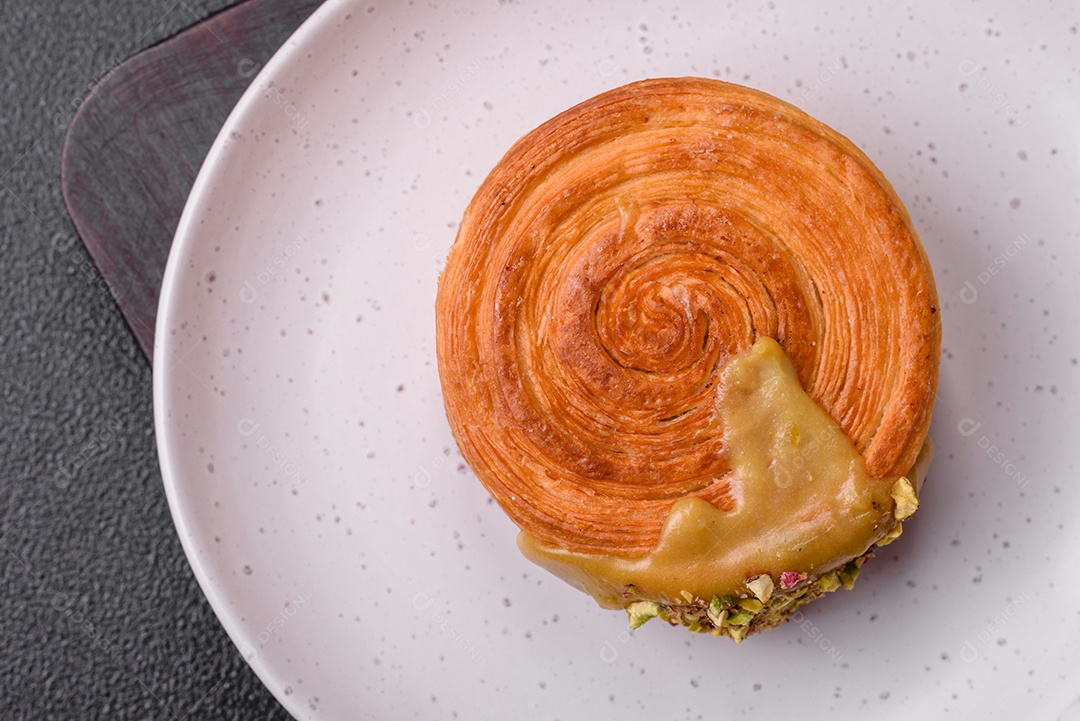 Croissant redondo de massa folhada com recheio de framboesa ou rolo de Nova Iorque sobre fundo escuro de concreto