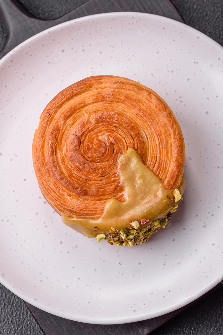 Croissant redondo de massa folhada com recheio de framboesa ou rolo de Nova Iorque sobre fundo escuro de concreto