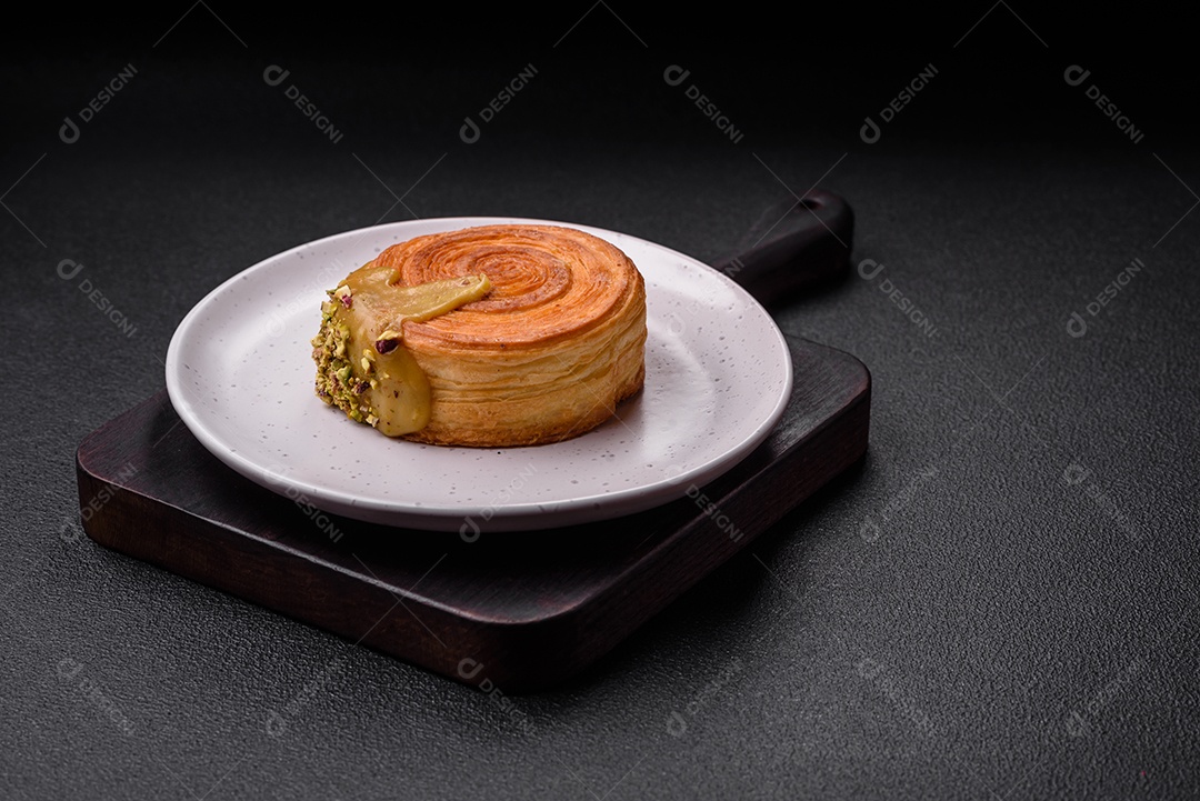 Croissant redondo de massa folhada com recheio de framboesa ou rolo de Nova Iorque sobre fundo escuro de concreto