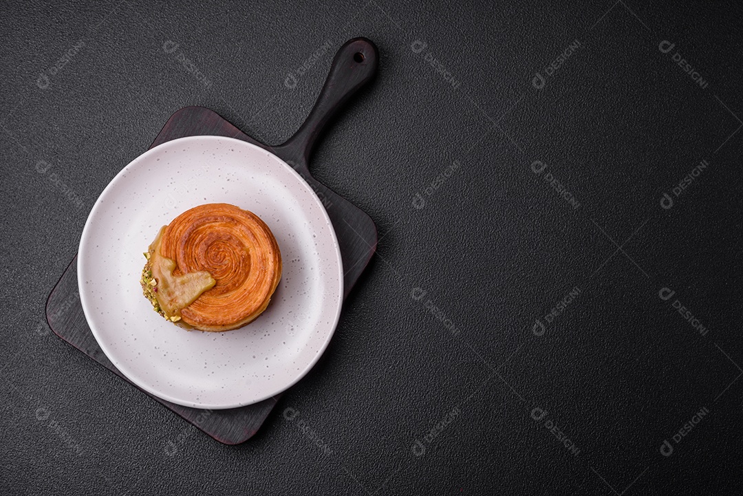 Croissant redondo de massa folhada com recheio de framboesa ou rolo de Nova Iorque sobre fundo escuro de concreto