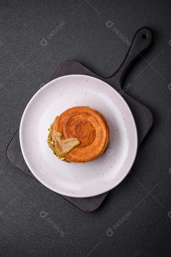 Croissant redondo de massa folhada com recheio de framboesa ou rolo de Nova Iorque sobre fundo escuro de concreto