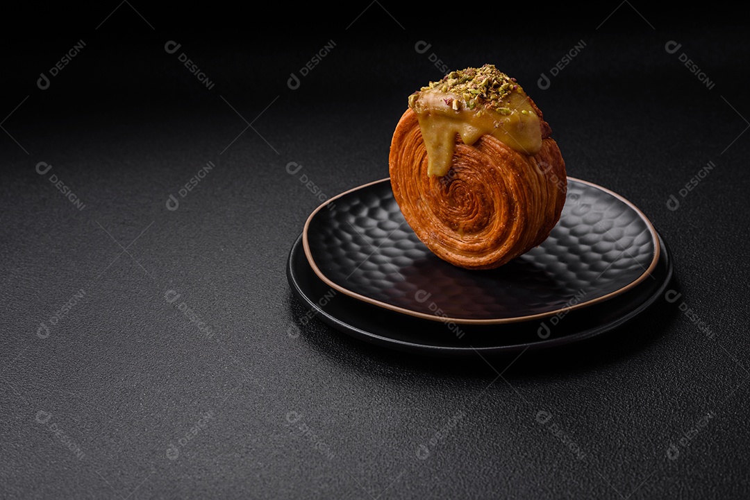 Croissant redondo de massa folhada com recheio de framboesa ou rolo de Nova Iorque sobre fundo escuro de concreto