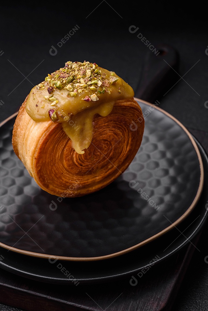 Croissant redondo de massa folhada com recheio de framboesa ou rolo de Nova Iorque sobre fundo escuro de concreto