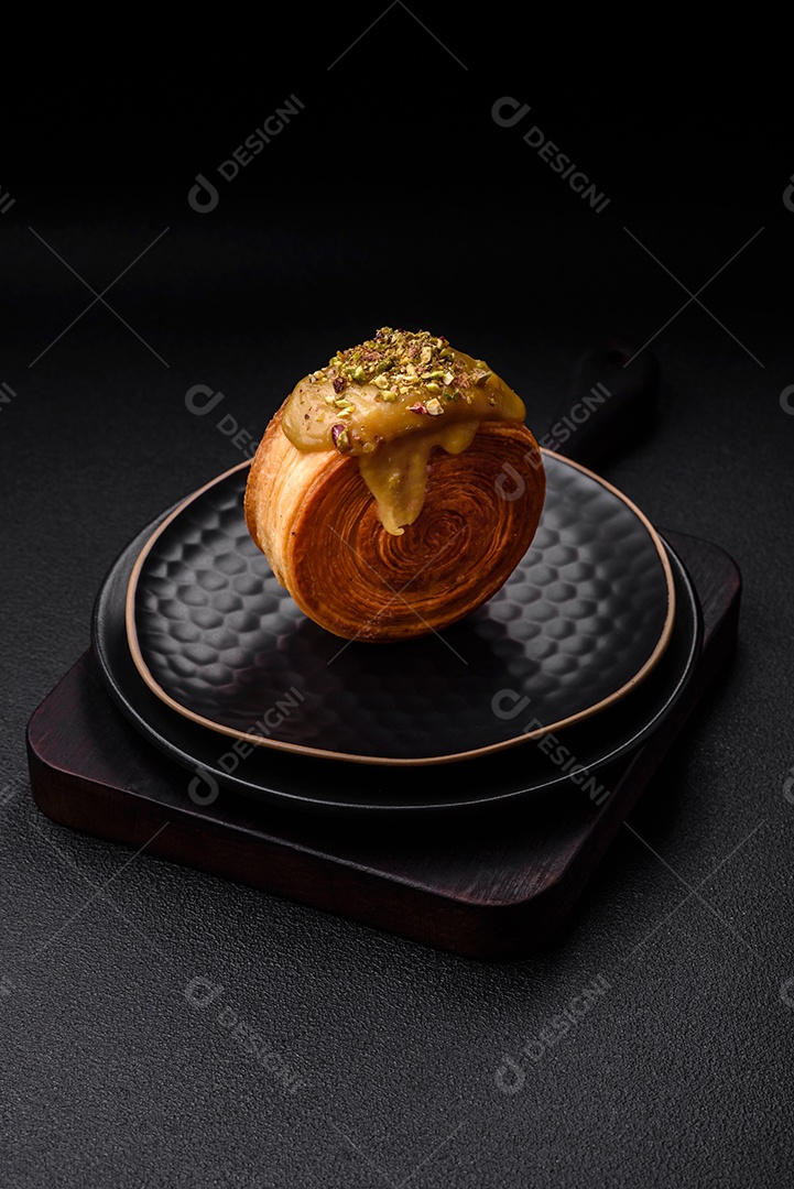 Croissant redondo de massa folhada com recheio de framboesa ou rolo de Nova Iorque sobre fundo escuro de concreto