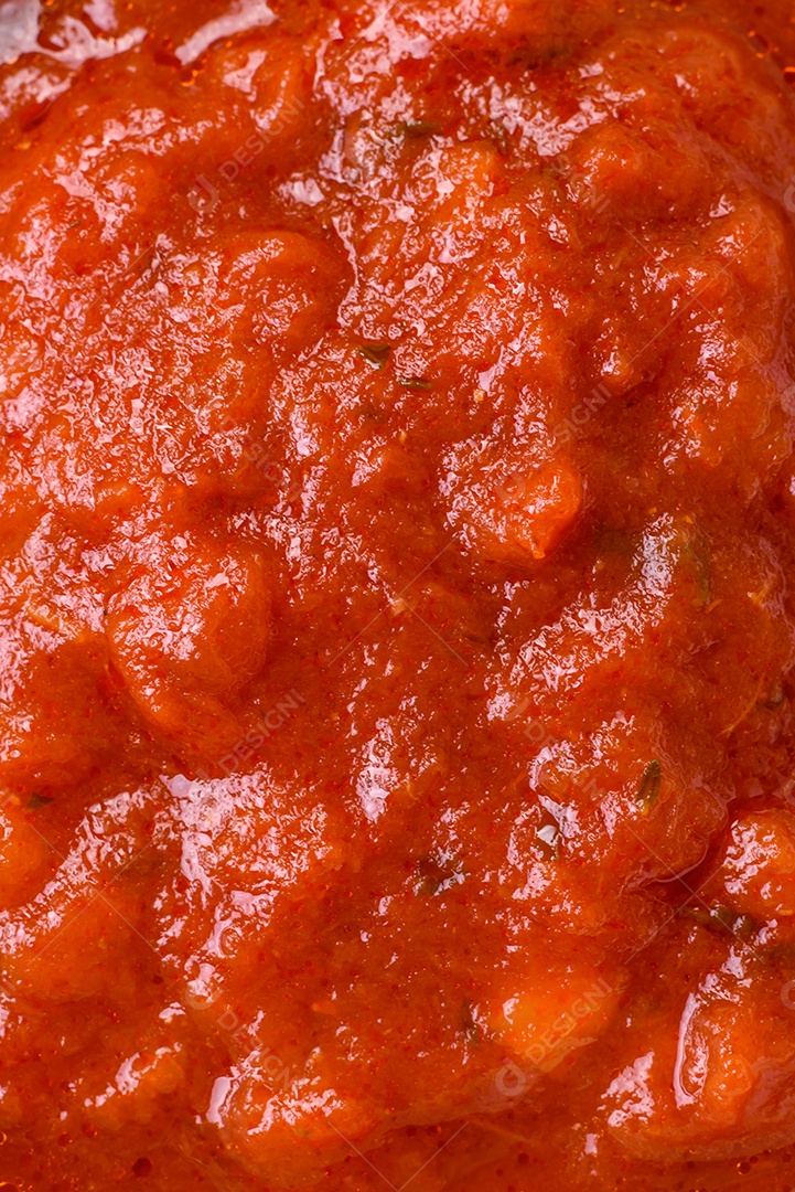 Delicioso molho Napoletana vermelho com cebola, sal, especiarias e ervas em uma tigela branca sobre fundo escuro de concreto