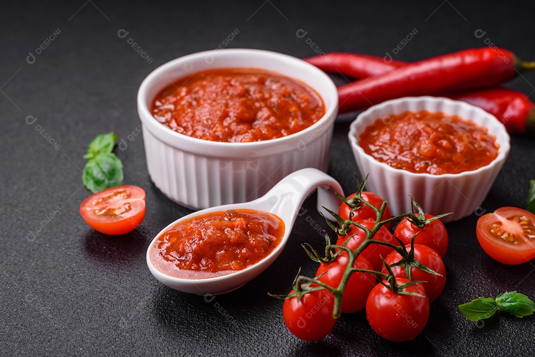 Delicioso molho Napoletana vermelho com cebola, sal, especiarias e ervas em uma tigela branca sobre fundo escuro de concreto