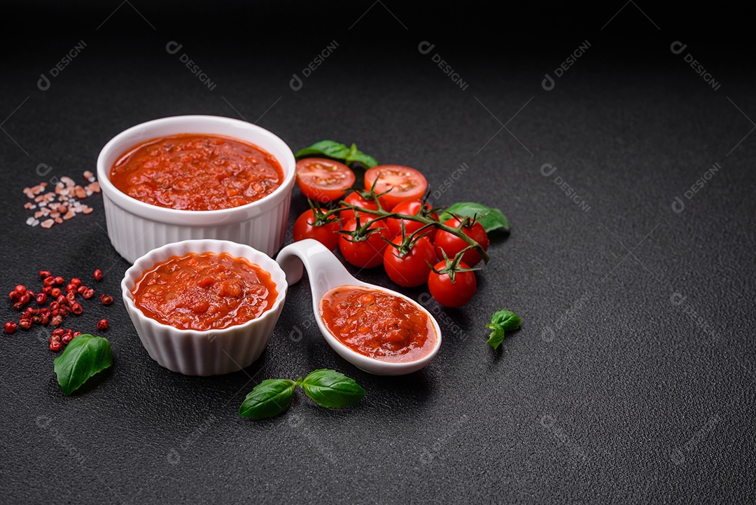 Delicioso molho Napoletana vermelho com cebola, sal, especiarias e ervas em uma tigela branca sobre fundo escuro de concreto