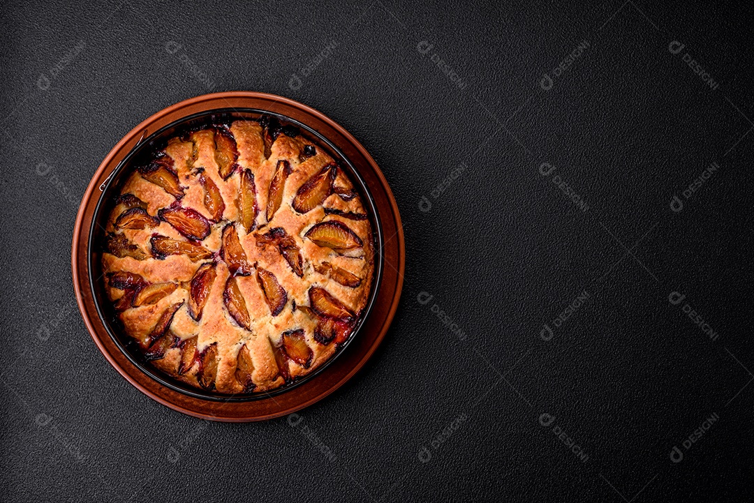 Deliciosa torta caseira aromática doce com ameixas maduras sobre um fundo escuro de concreto
