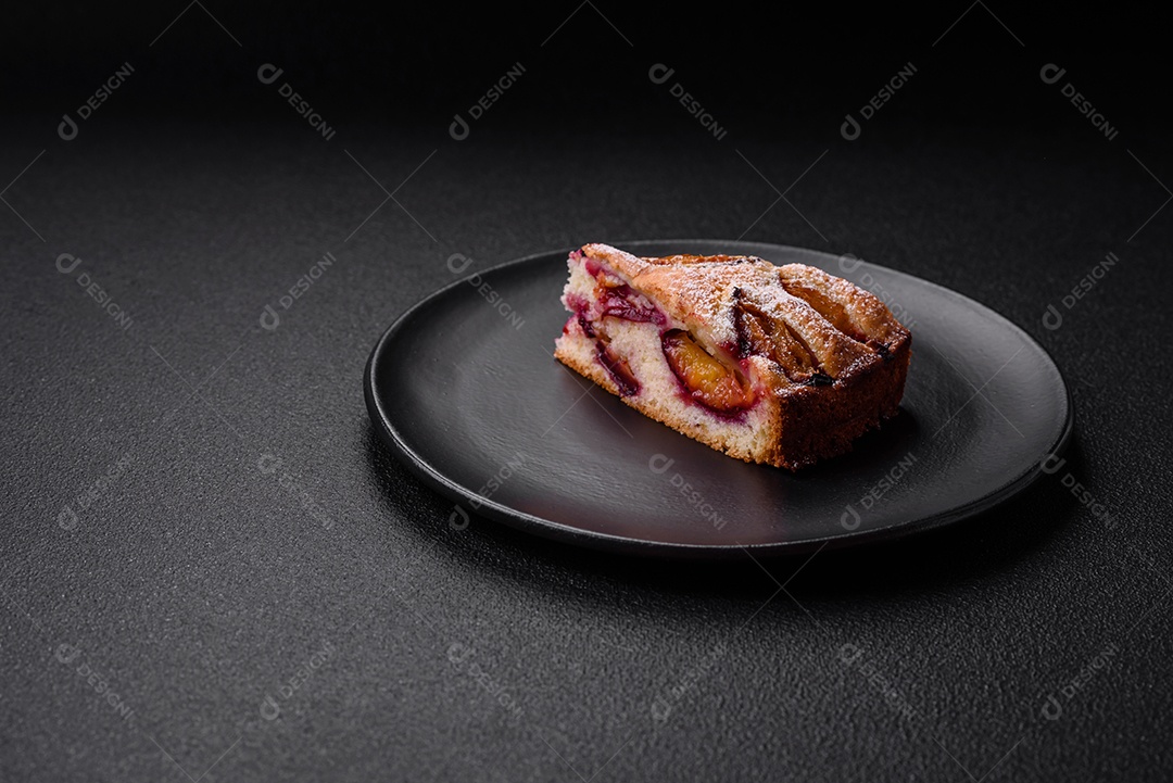 Deliciosa torta caseira aromática doce com ameixas maduras sobre um fundo escuro de concreto