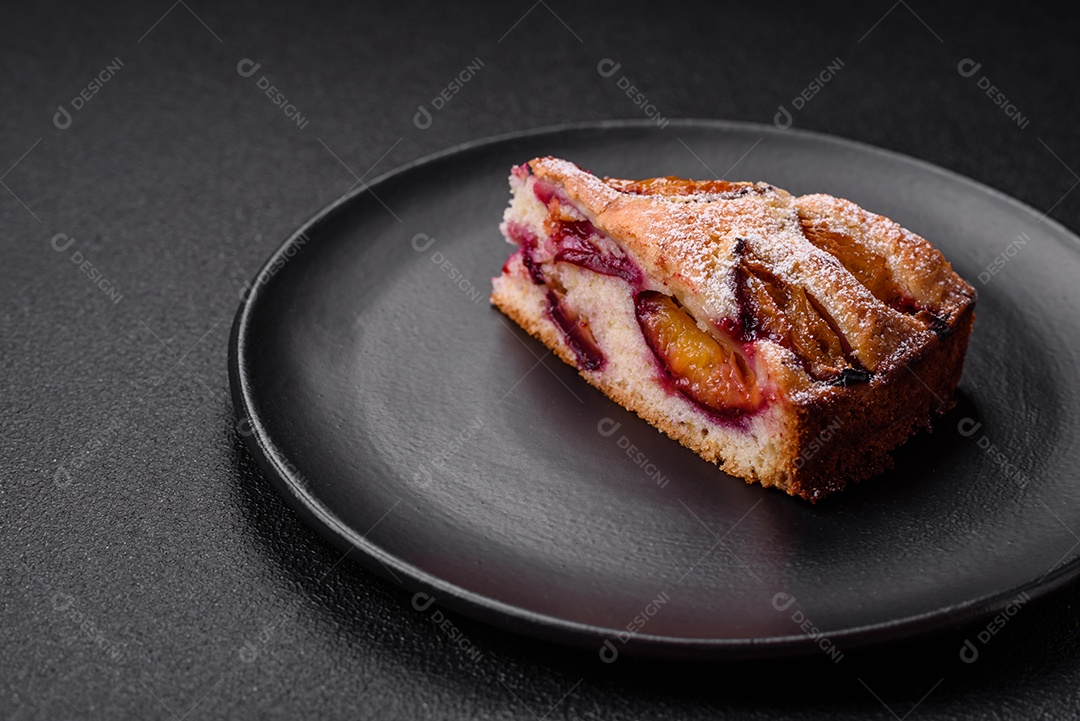 Deliciosa torta caseira aromática doce com ameixas maduras sobre um fundo escuro de concreto