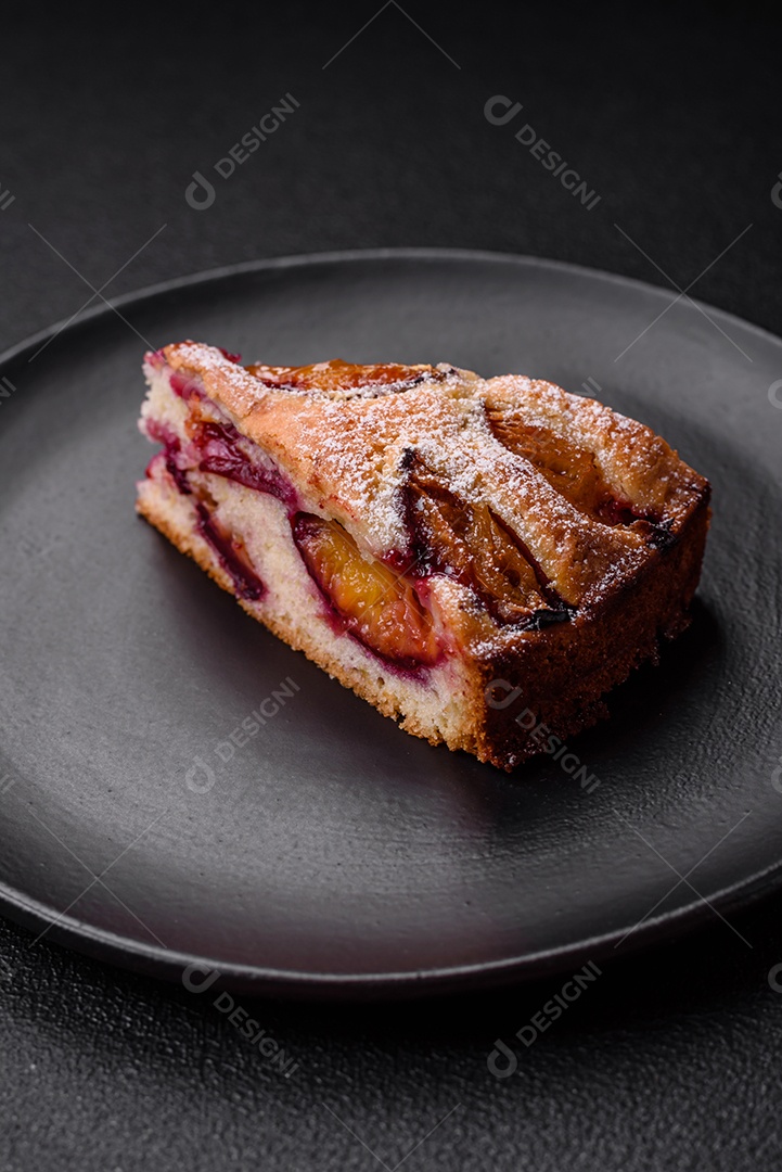 Deliciosa torta caseira aromática doce com ameixas maduras sobre um fundo escuro de concreto