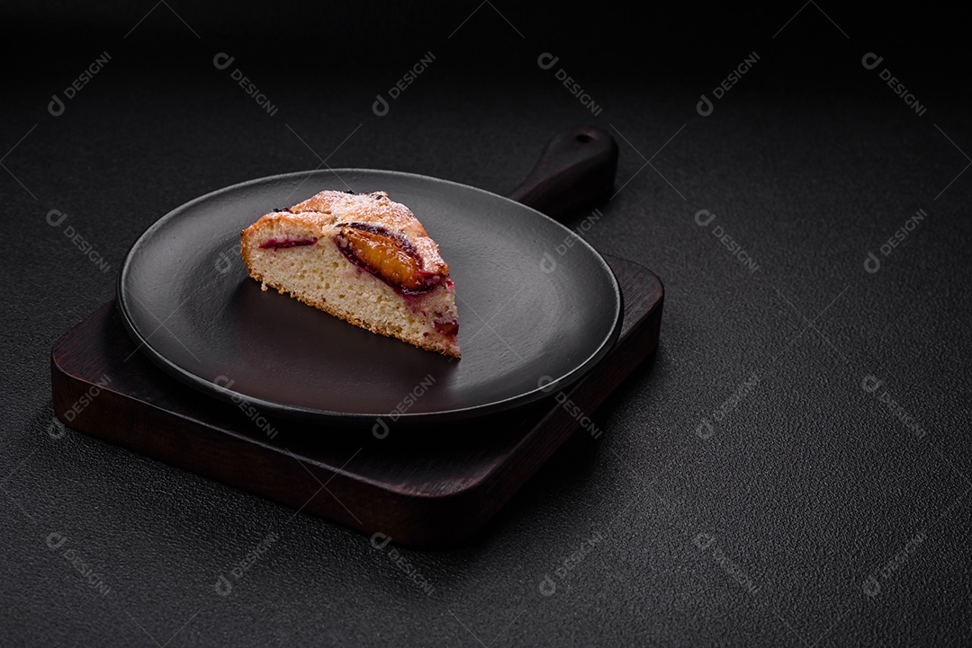 Deliciosa torta caseira aromática doce com ameixas maduras sobre um fundo escuro de concreto