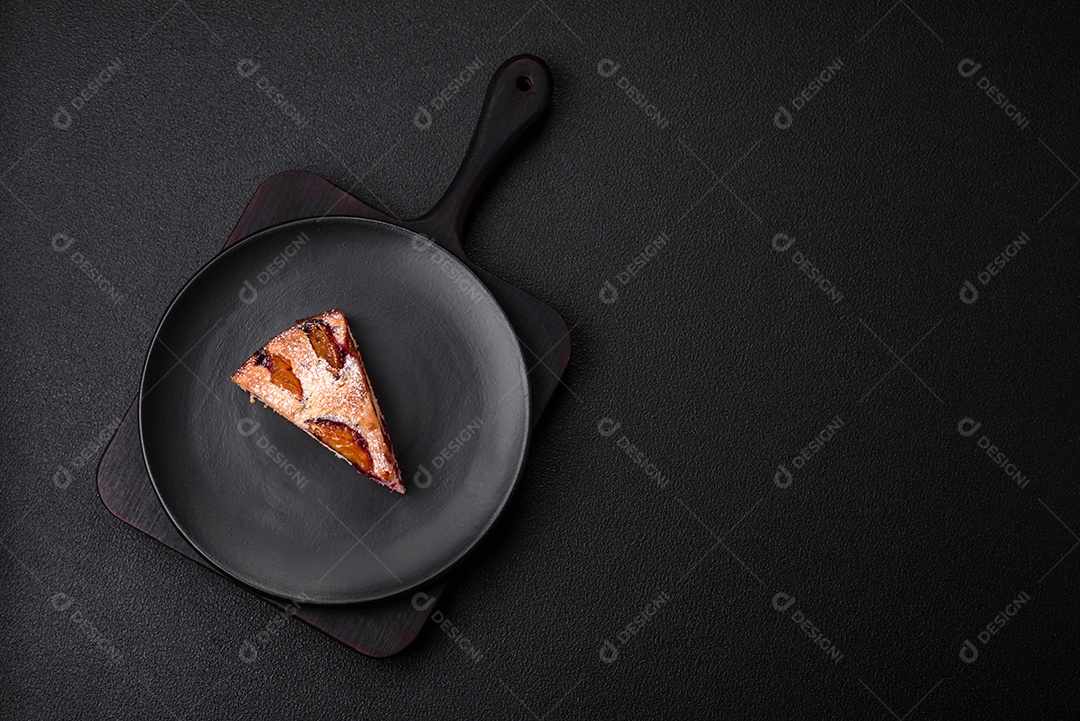 Deliciosa torta caseira aromática doce com ameixas maduras sobre um fundo escuro de concreto