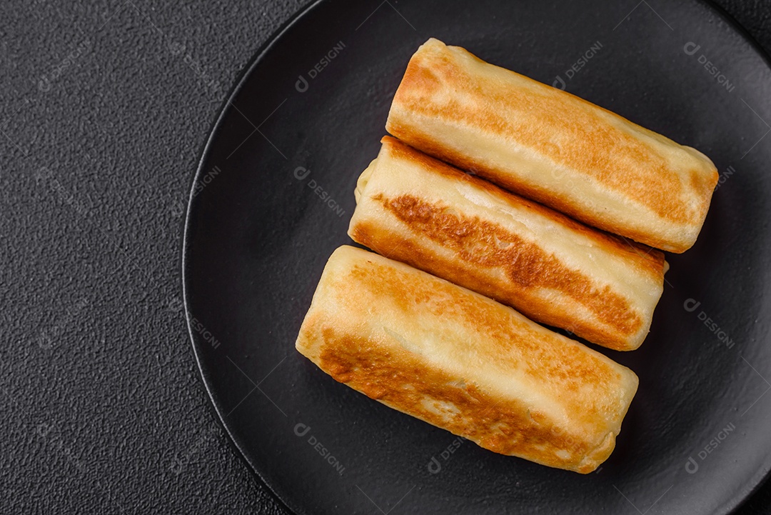 Deliciosas panquecas fritas caseiras frescas com brócolis e carne ou peixe com sal e especiarias sobre um fundo escuro de concreto